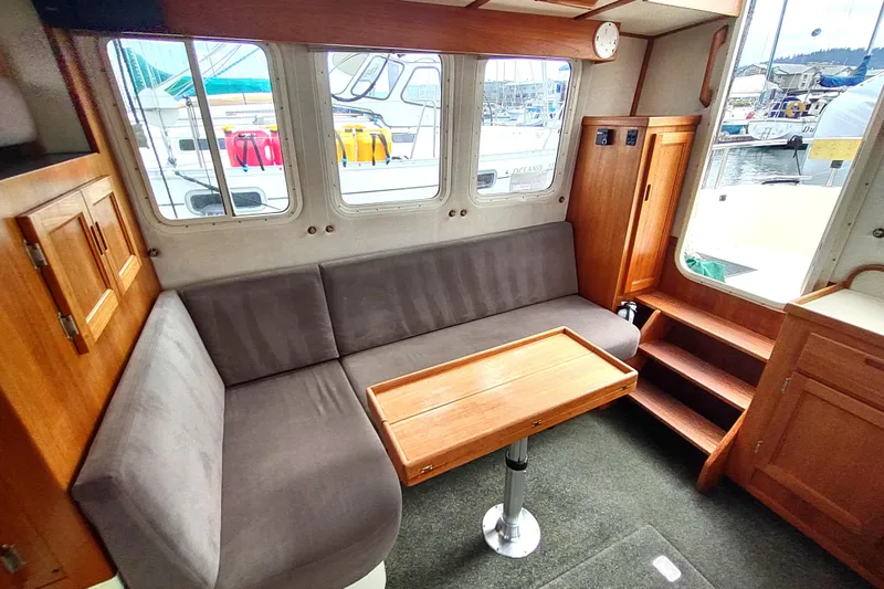 Bernardi Yacht Photos Pics Interior of a 2004 Nordic Tug 32 with cozy seating and wooden accents.