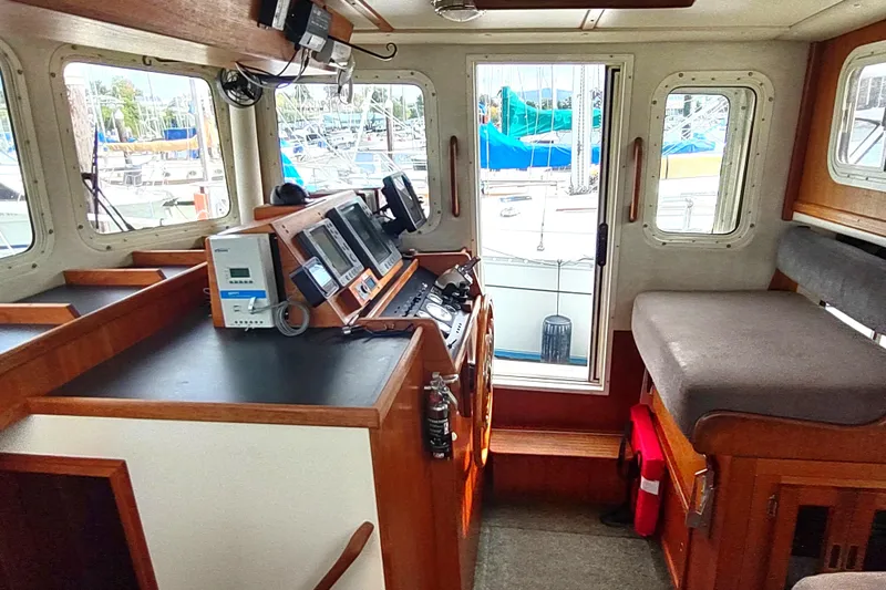 Bernardi Yacht Photos Pics Interior of a 2004 Nordic Tug 32, featuring navigation equipment and seating.