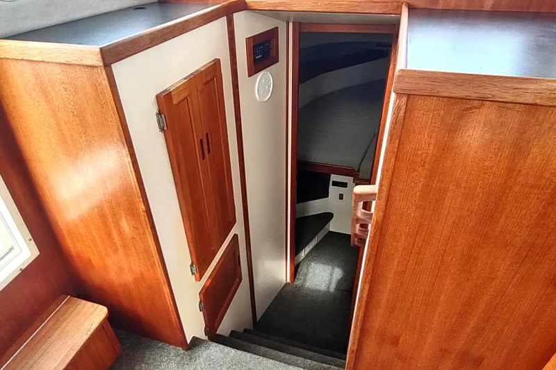 Bernardi Yacht Photos Pics Interior view of 2004 Nordic Tug 32, featuring wooden cabinetry and carpeted stairs.