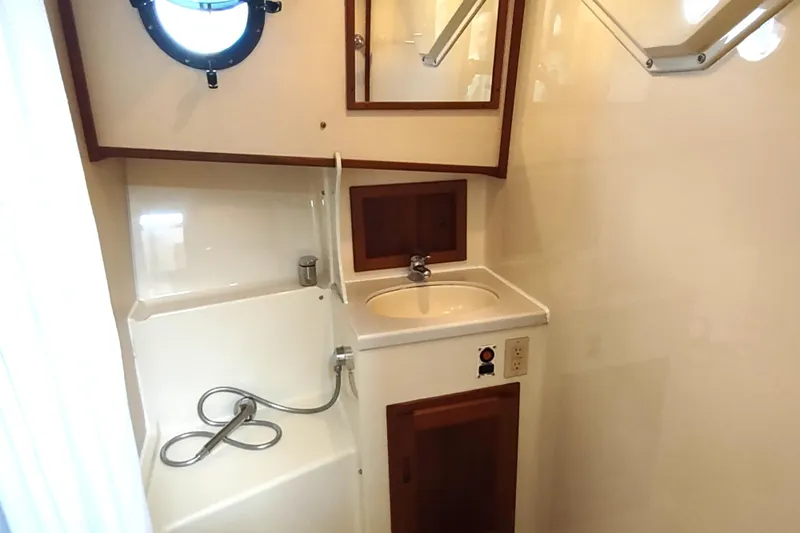 Bernardi Yacht Photos Pics 2004 Nordic Tug 32 bathroom with sink, shower, and porthole window.