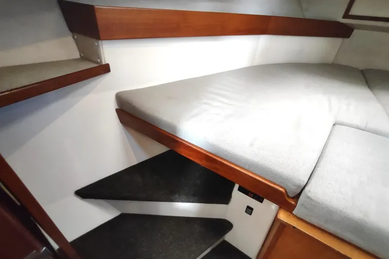 Bernardi Yacht Photos Pics Interior cabin of a 2004 Nordic Tug 32 with cushioned bed and wooden accents.