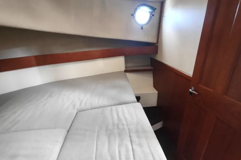 Bernardi Yacht Photos Pics Cozy cabin interior of 2004 Nordic Tug 32 with wooden accents and porthole.