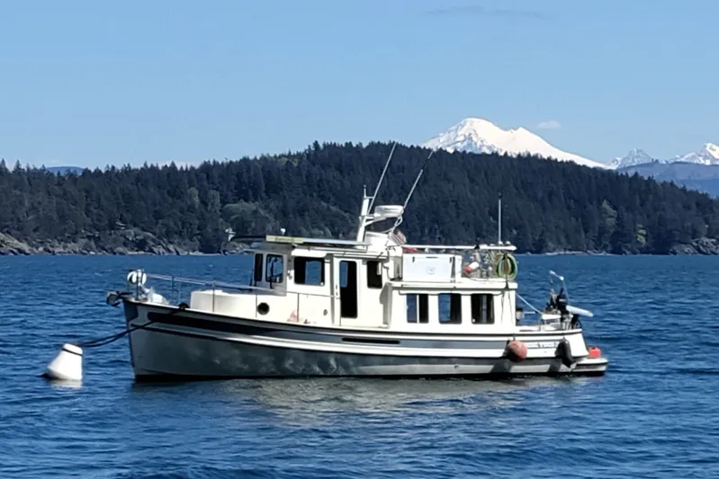 Bernardi Yacht Photos Pics 2004 Nordic Tug 32 boat on scenic lake with forested mountains in background.