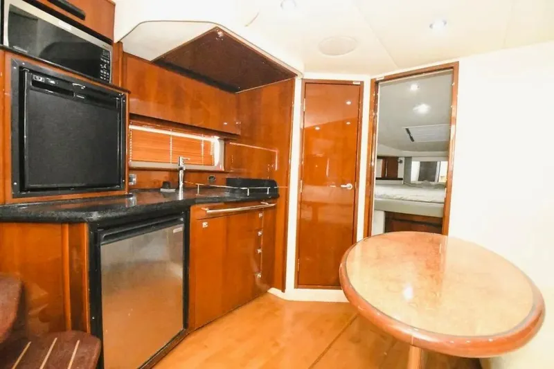  Yacht Photos Pics Luxurious interior of 2010 Sea Ray 390 Sundancer yacht with kitchenette and dining area.