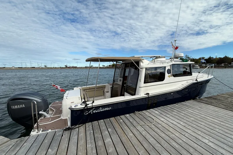  Yacht Photos Pics 2025 Ranger Tugs R-27 boat docked, featuring Yamaha outboard motor, under a partly cloudy sky.