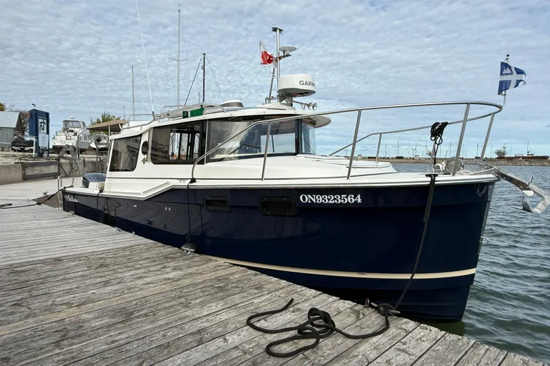  Yacht Photos Pics 2025 Ranger Tugs R-27 boat docked at a marina under a cloudy sky.