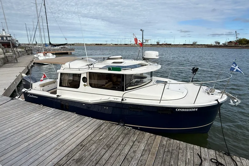  Yacht Photos Pics 2025 Ranger Tugs R-27 boat docked at a marina, featuring a sleek design.