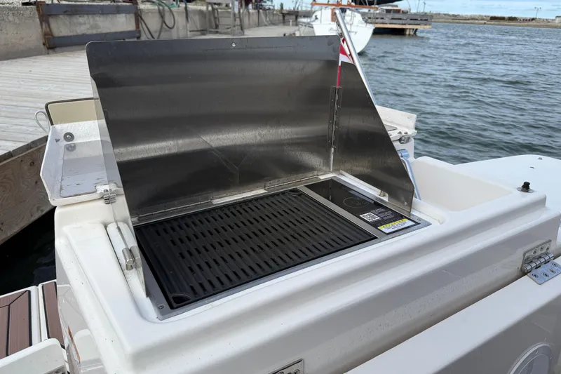  Yacht Photos Pics Outdoor grill on 2025 Ranger Tugs R-27 boat, docked by the water.