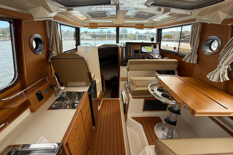  Yacht Photos Pics 2025 Ranger Tugs R-27 interior with wood finish, kitchenette, and navigation area.