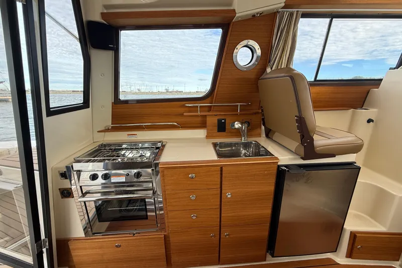  Yacht Photos Pics Interior of 2025 Ranger Tugs R-27 boat with kitchen, stove, sink, and seating.