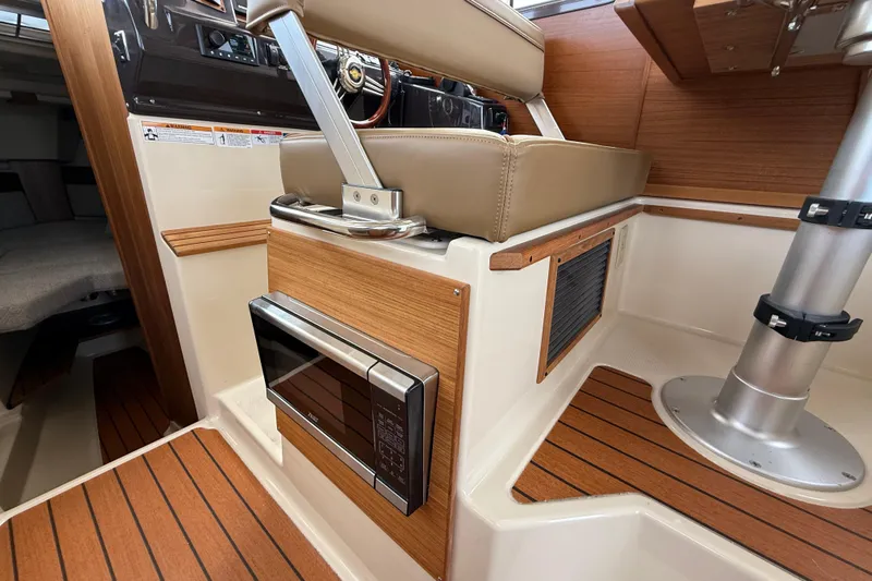  Yacht Photos Pics 2025 Ranger Tugs R-27 interior with wood accents and built-in microwave.