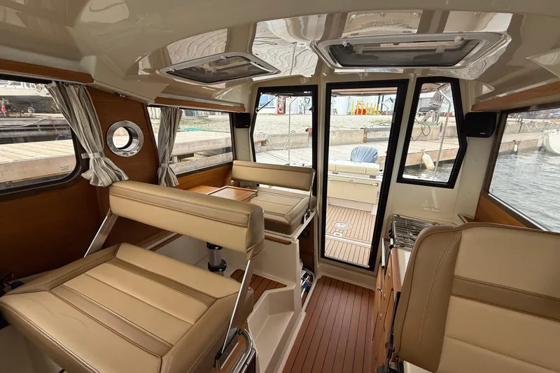  Yacht Photos Pics Interior of 2025 Ranger Tugs R-27 boat with beige seating and wood accents.