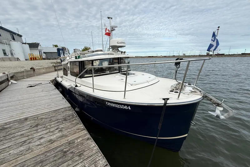  Yacht Photos Pics 2025 Ranger Tugs R-27 docked at marina with flags and Garmin equipment.