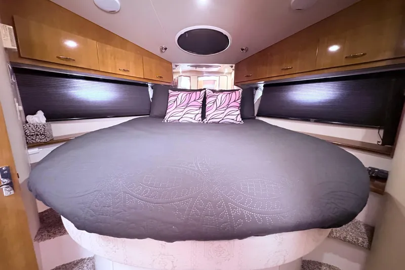 Elevate Yacht Photos Pics Luxurious bedroom interior of 2003 Carver 360 Sport Sedan with cozy bedding and wooden cabinets.