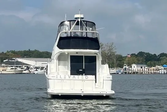 Elevate Yacht Photos Pics 2003 Carver 360 Sport Sedan yacht on water, rear view, marina background.