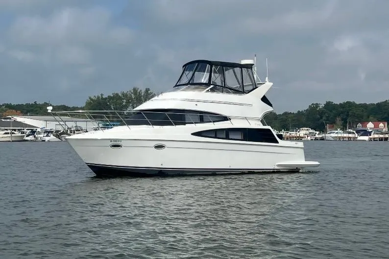Elevate Yacht Photos Pics 2003 Carver 360 Sport Sedan yacht on calm water, with marina background.