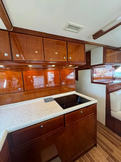 Spill Yacht Photos Pics 2007 Bertram 510 Convertible yacht kitchen with wooden cabinets and modern appliances.