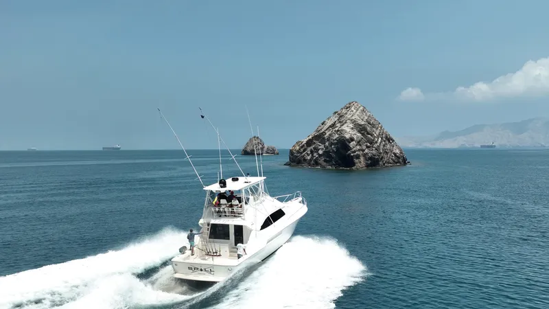 Spill Yacht Photos Pics 2007 Bertram 510 Convertible yacht cruising near rocky islands.