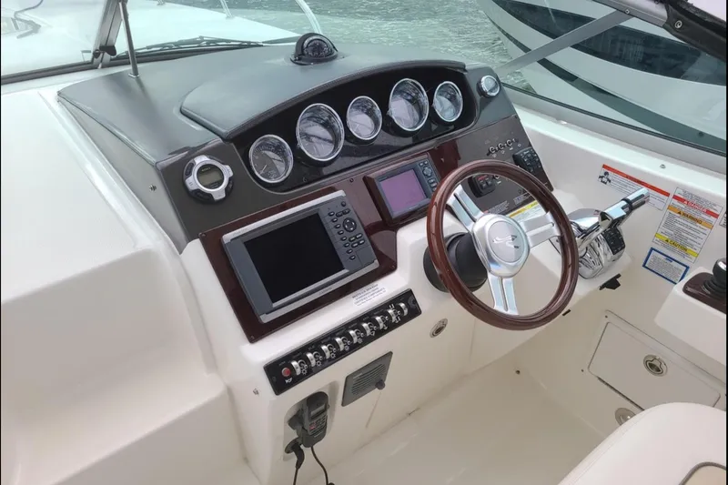  Yacht Photos Pics 2011 Sea Ray 310 Sundancer helm with gauges, steering wheel, and navigation equipment.