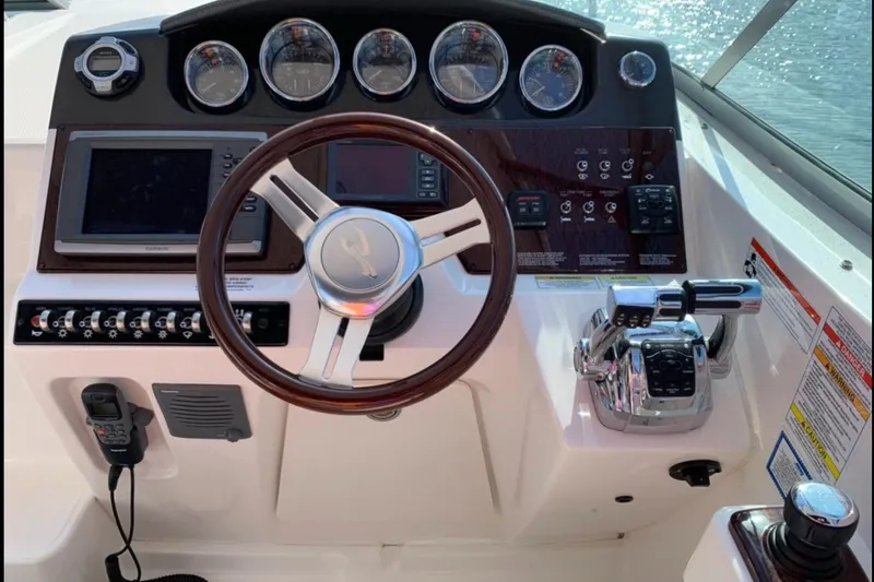  Yacht Photos Pics Cockpit of 2011 Sea Ray 310 Sundancer with steering wheel and control panel.