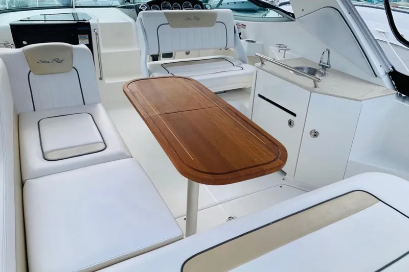  Yacht Photos Pics 2011 Sea Ray 310 Sundancer interior with seating, wooden table, and kitchenette.