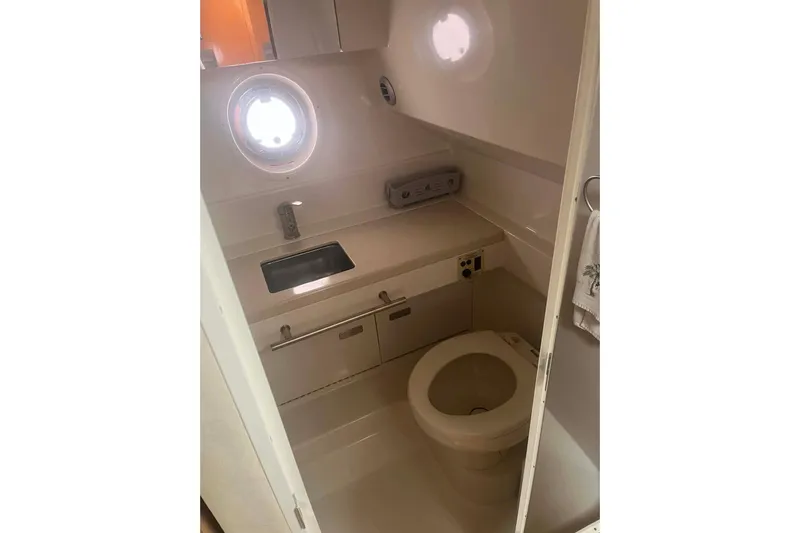  Yacht Photos Pics 2011 Sea Ray 310 Sundancer bathroom with sink, toilet, and porthole window.