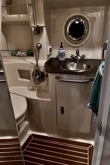  Yacht Photos Pics 2012 Sea Ray 350 Sundancer bathroom with sink, porthole, and wooden floor.