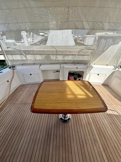  Yacht Photos Pics 2007 Riviera 47 Convertible yacht deck with wooden table and storage compartments.