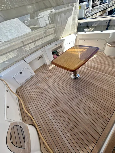  Yacht Photos Pics 2007 Riviera 47 Convertible yacht deck with wooden table and seating area.