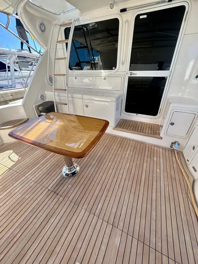  Yacht Photos Pics 2007 Riviera 47 Convertible yacht deck with wooden table and ladder.