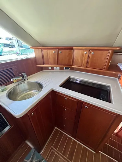  Yacht Photos Pics 2007 Riviera 47 Convertible yacht kitchen with wooden cabinets and modern sink.