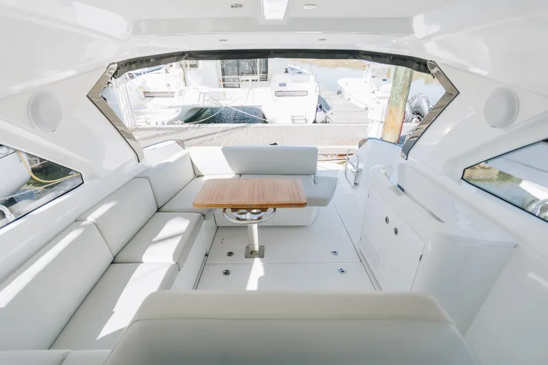  Yacht Photos Pics Interior of 2023 Beneteau Gran Turismo 41 yacht, featuring sleek white seating and a wooden table.