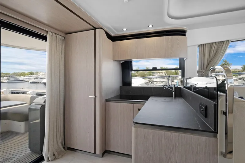 Guyal Yacht Photos Pics Luxurious interior of 2024 Azimut Fly 53 yacht with modern kitchen and scenic marina view.