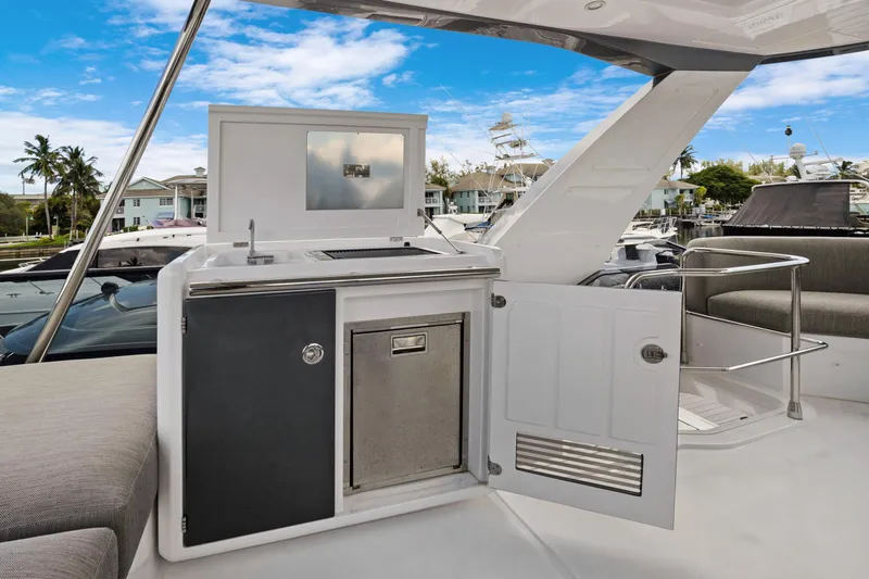 Guyal Yacht Photos Pics Outdoor kitchenette on 2024 Azimut Fly 53 yacht, featuring sink and storage, docked in marina.