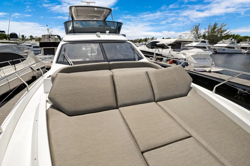 Guyal Yacht Photos Pics 2024 Azimut Fly 53 yacht with spacious sunbed, docked at marina under blue sky.