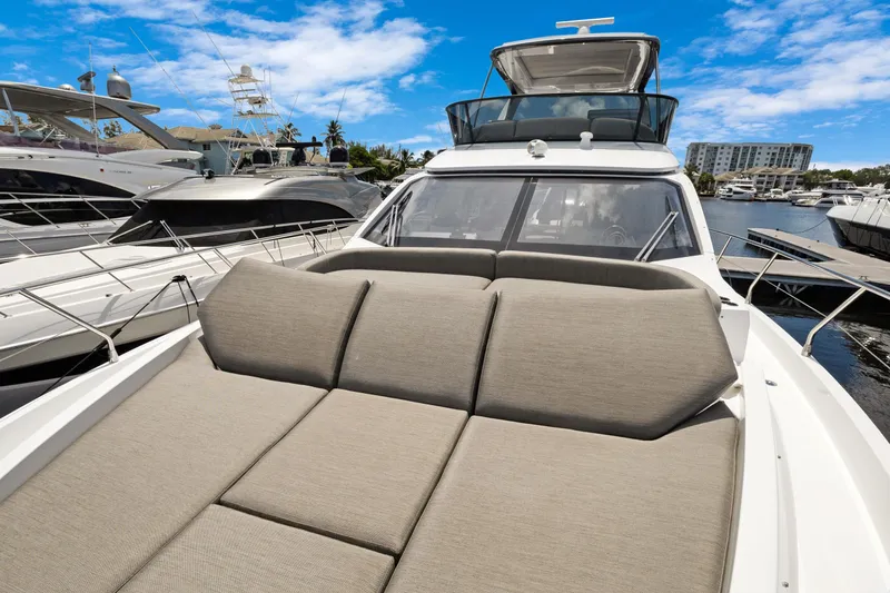 Guyal Yacht Photos Pics 2024 Azimut Fly 53 yacht with spacious deck, docked in a marina under blue skies.