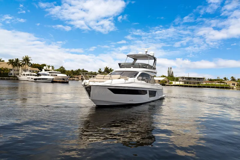 Guyal Yacht Photos Pics 2024 Azimut Fly 53 yacht cruising on a sunny day, surrounded by waterfront homes.