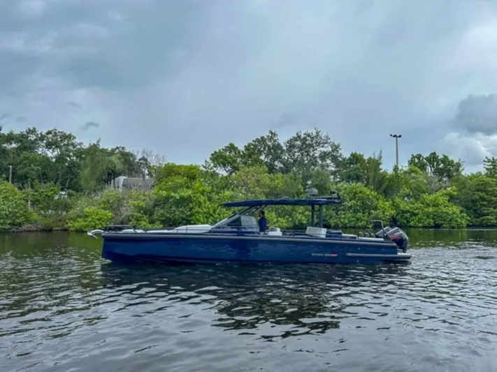  Yacht Photos Pics 2024 BRABUS Shadow 1000 ST boat on a calm river with lush greenery.