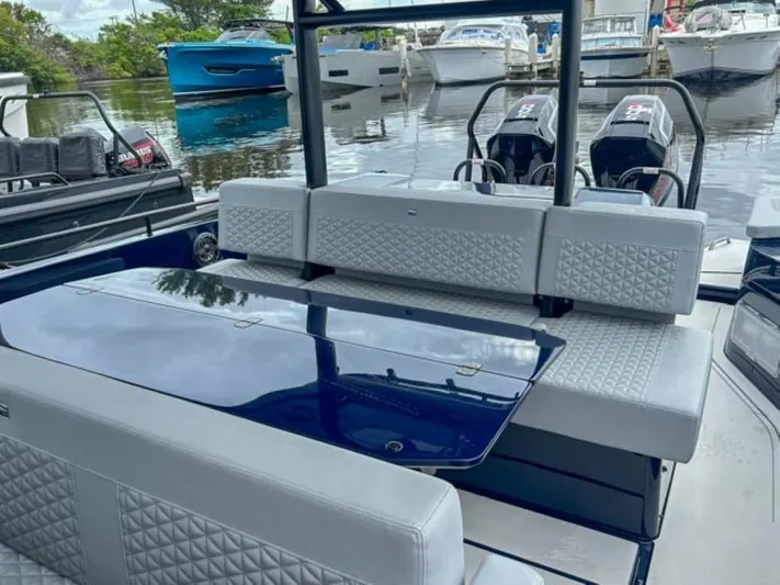  Yacht Photos Pics 2024 BRABUS Shadow 1000 ST luxury boat interior with seating and table, docked at marina.