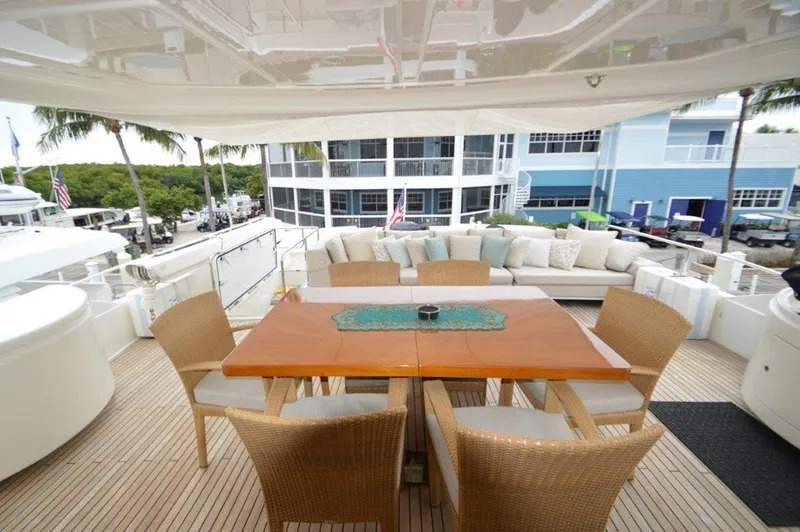Slainte III Yacht Photos Pics Luxurious 2013 Custom Line Navetta yacht deck with dining area and comfortable seating.