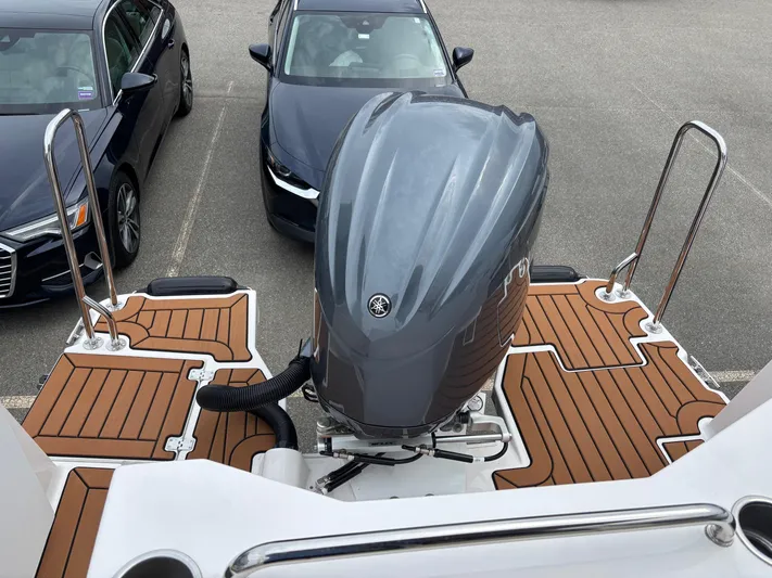  Yacht Photos Pics 2025 Ranger Tugs R-25 boat with outboard motor, parked near cars.