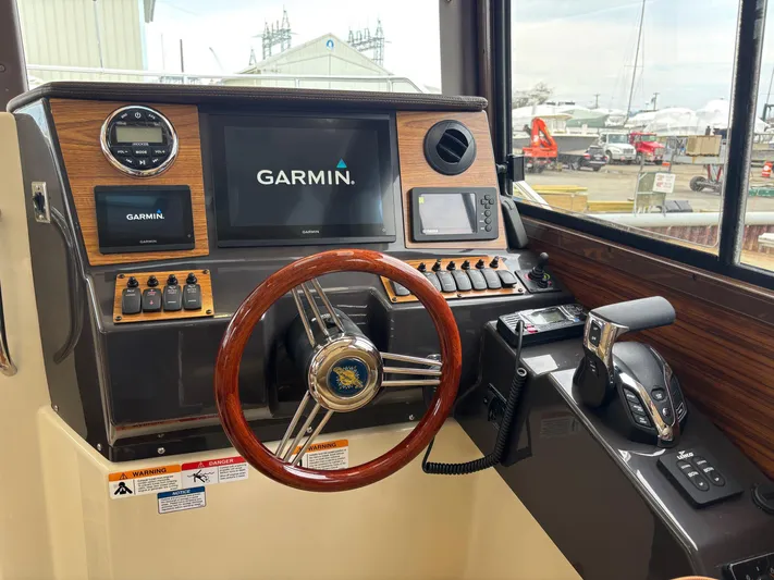  Yacht Photos Pics 2025 Ranger Tugs R-25 helm with Garmin navigation system and wooden steering wheel.