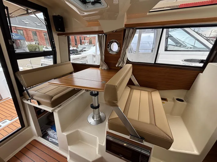  Yacht Photos Pics 2025 Ranger Tugs R-25 interior with seating, table, and windows, showcasing modern design.
