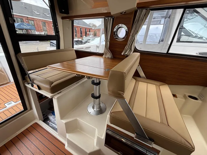  Yacht Photos Pics Interior of 2025 Ranger Tugs R-25, featuring a cozy dining area with wood accents.