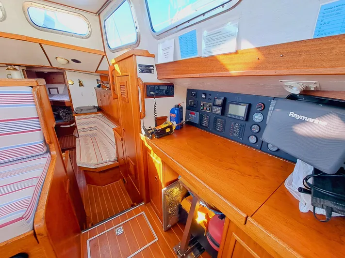  Yacht Photos Pics Interior of 1990 Van De Stadt 44 Deck Saloon, featuring navigation equipment and wooden furnishings.