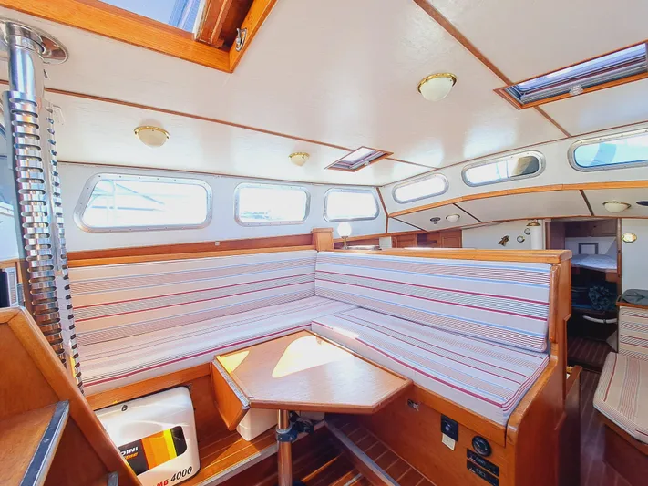  Yacht Photos Pics Interior of 1990 Van De Stadt 44 Deck Saloon yacht with striped seating and wooden accents.