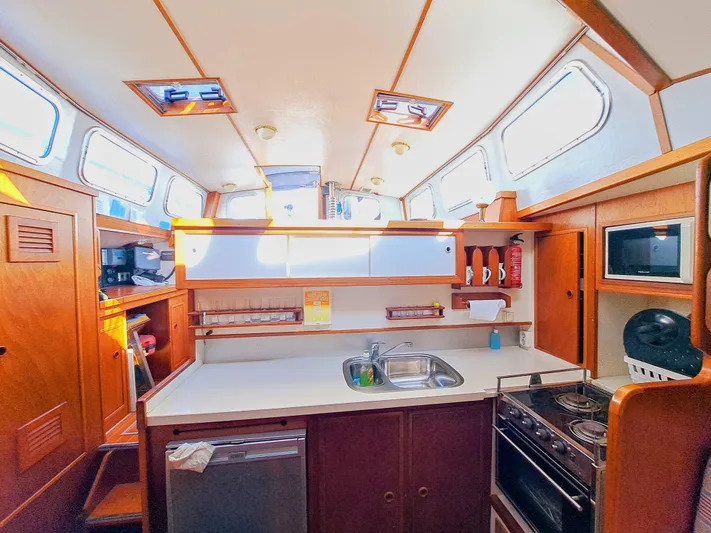  Yacht Photos Pics Interior of 1990 Van De Stadt 44 Deck Saloon yacht, featuring a well-equipped kitchen area.