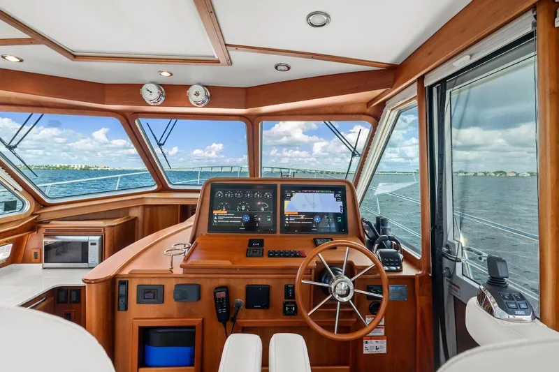 Balahula Yacht Photos Pics 2019 Sabre 45 Salon Express helm with navigation system, wooden interior, and ocean view.