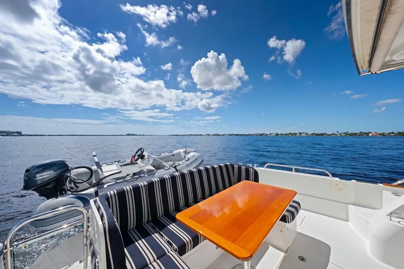 Balahula Yacht Photos Pics 2019 Sabre 45 Salon Express yacht with striped seating, wooden table, and scenic ocean view.