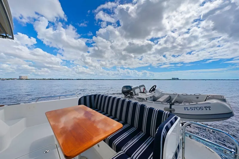 Balahula Yacht Photos Pics 2019 Sabre 45 Salon Express yacht with striped seating, wooden table, and scenic ocean view.